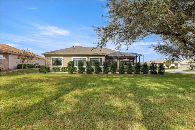 back of house with a lawn and a lanai