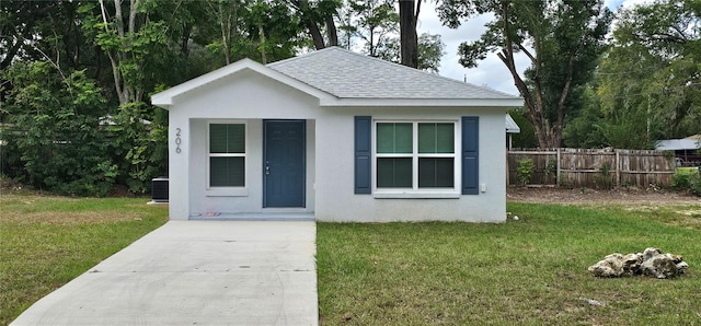 view of front of house with cooling unit and a front lawn