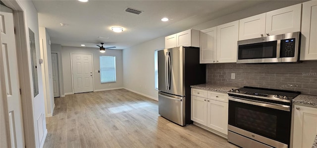 kitchen featuring light stone counters, appliances with stainless steel finishes, light hardwood / wood-style floors, white cabinets, and ceiling fan