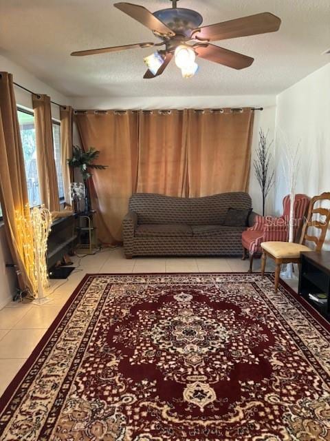 living room with light tile patterned floors, a textured ceiling, and ceiling fan