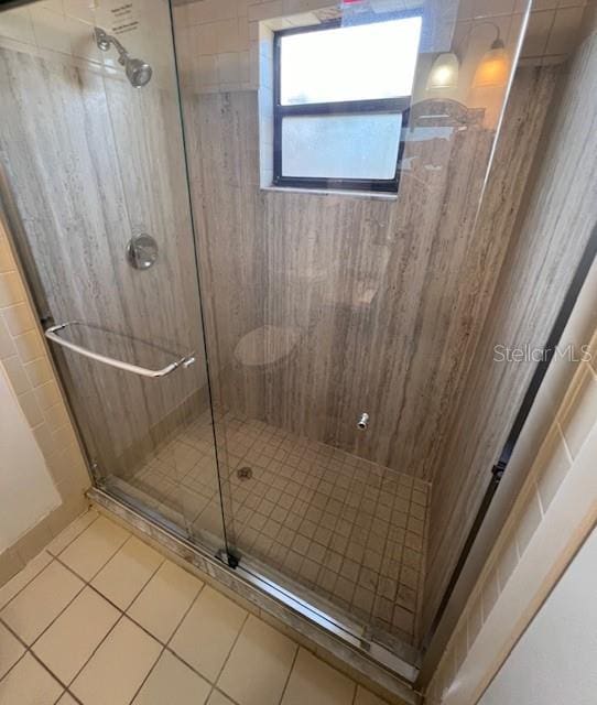 bathroom with tile patterned flooring and a shower with shower door