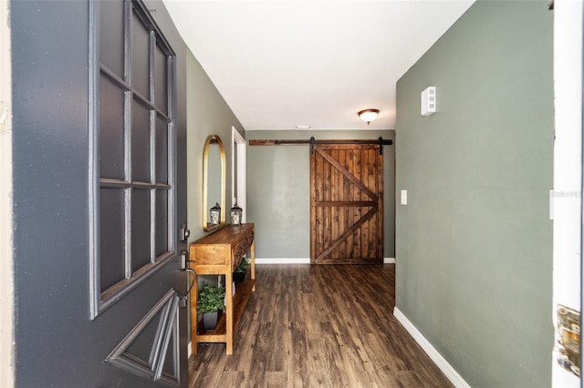 entryway with dark wood-type flooring and a barn door