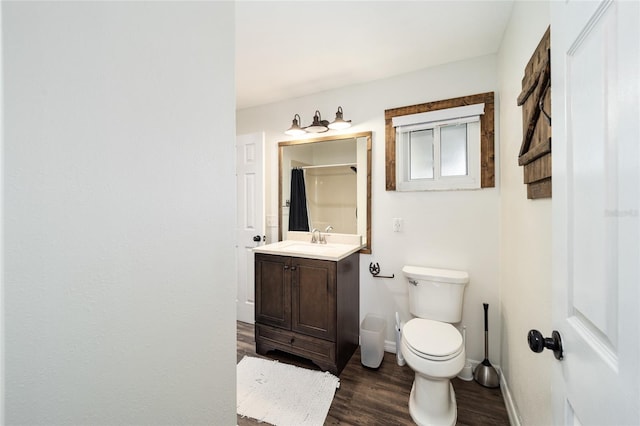 bathroom with hardwood / wood-style flooring, vanity, toilet, and walk in shower