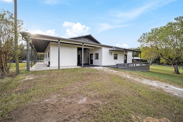 rear view of property with a lawn and a carport