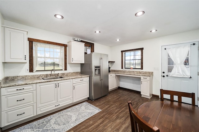 kitchen featuring white cabinetry, light stone countertops, stainless steel refrigerator with ice dispenser, sink, and dark wood-type flooring