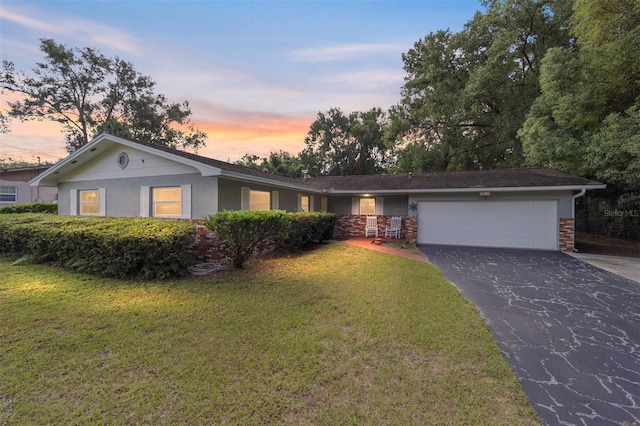 ranch-style home with a yard and a garage