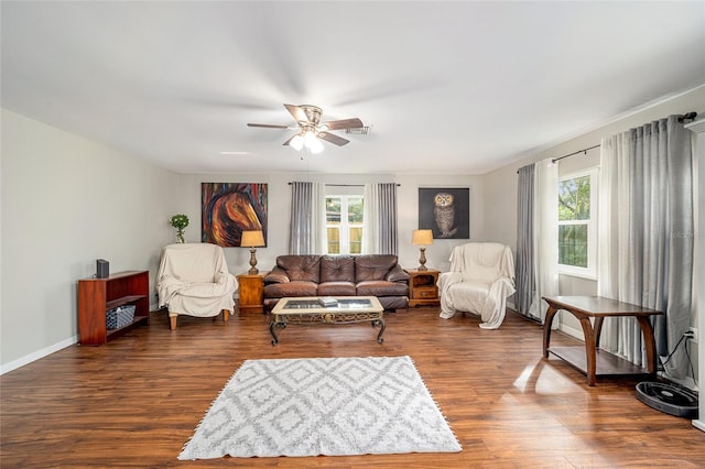 living room with ceiling fan and dark wood-type flooring