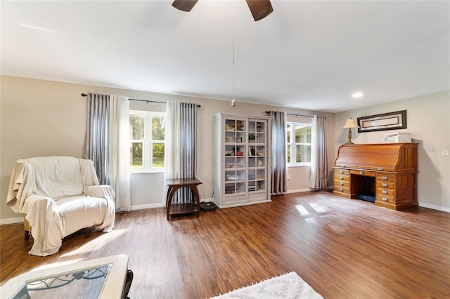 living area with wood-type flooring and ceiling fan