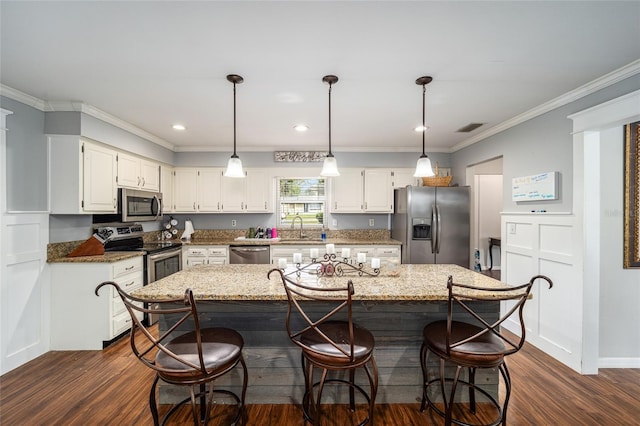 kitchen featuring light stone countertops, a center island, stainless steel appliances, and dark hardwood / wood-style floors