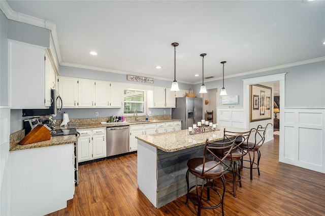 kitchen with light stone countertops, dark hardwood / wood-style flooring, stainless steel appliances, a center island, and white cabinetry