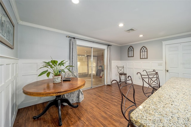 dining space with ornamental molding and hardwood / wood-style flooring