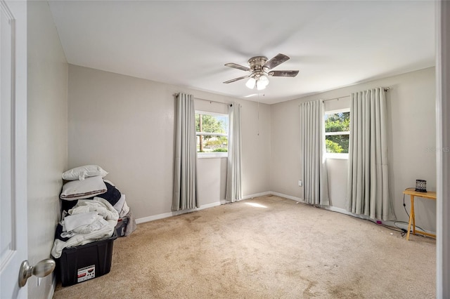 carpeted spare room featuring ceiling fan