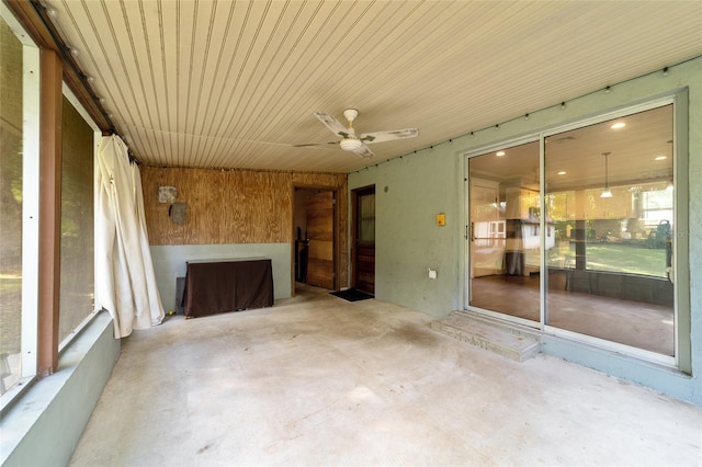 unfurnished sunroom featuring ceiling fan