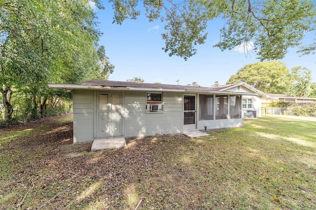 back of house with a yard, cooling unit, and a sunroom