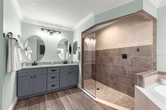 bathroom with hardwood / wood-style flooring, a textured ceiling, independent shower and bath, vanity, and crown molding