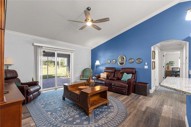 living room featuring dark hardwood / wood-style flooring, ceiling fan, vaulted ceiling, and ornamental molding