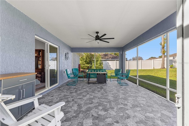 unfurnished sunroom featuring ceiling fan