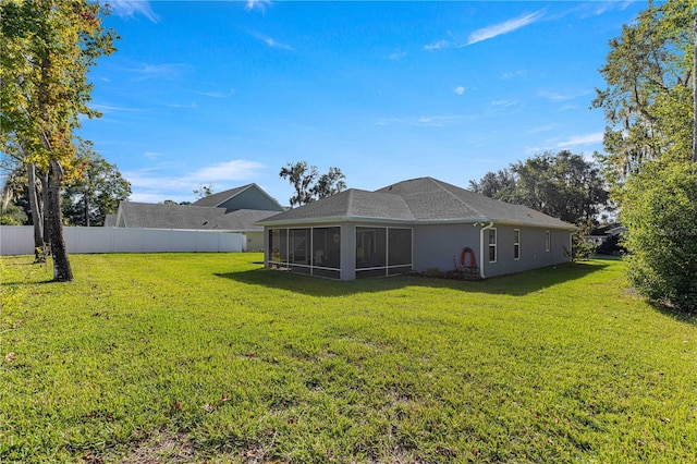 rear view of property with a lawn and a sunroom