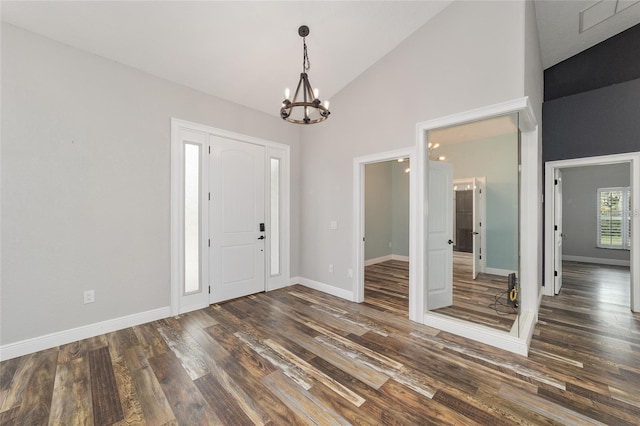 entrance foyer featuring high vaulted ceiling, dark hardwood / wood-style flooring, and a chandelier