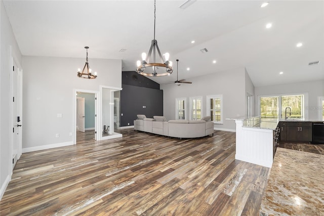 living room featuring dark hardwood / wood-style floors, ceiling fan with notable chandelier, sink, and high vaulted ceiling