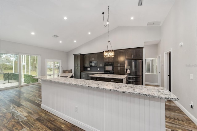 kitchen featuring stainless steel appliances, dark brown cabinetry, dark hardwood / wood-style floors, pendant lighting, and a large island with sink