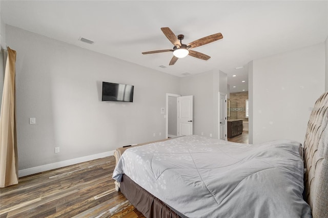 bedroom featuring dark wood-type flooring, ceiling fan, and ensuite bath