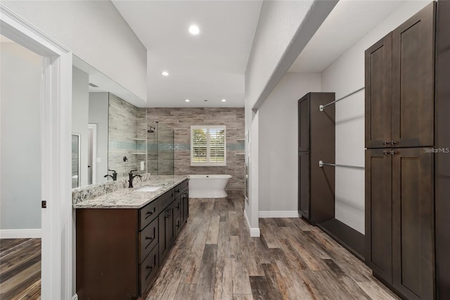 bathroom featuring tile walls, shower with separate bathtub, wood-type flooring, and vanity