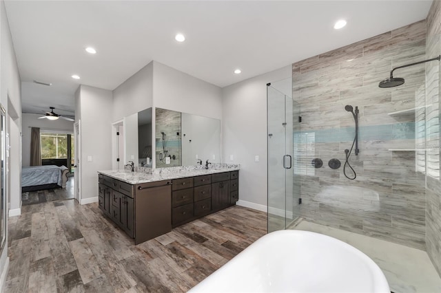 bathroom with ceiling fan, wood-type flooring, vanity, and shower with separate bathtub