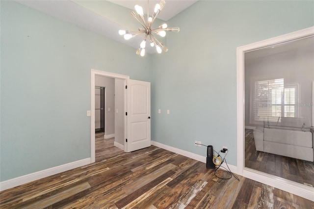 clothes washing area featuring dark wood-type flooring, a high ceiling, and a notable chandelier