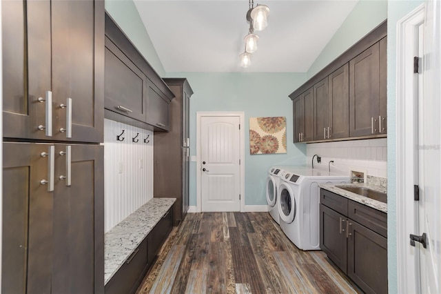 clothes washing area featuring washer and clothes dryer, dark wood-type flooring, cabinets, and sink