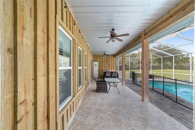 exterior space with ceiling fan and a pool