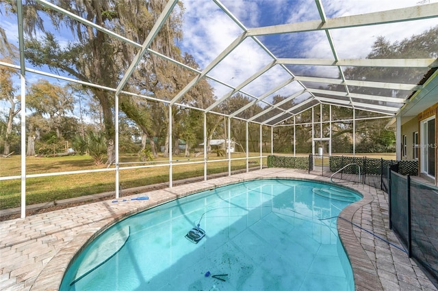 view of swimming pool with a patio area, a lawn, and a lanai