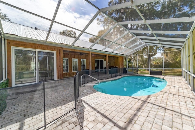 view of swimming pool featuring glass enclosure and a patio area