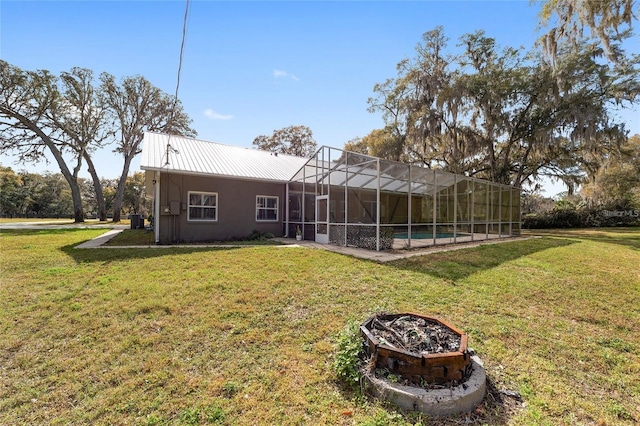 back of house featuring a swimming pool, a lawn, and glass enclosure