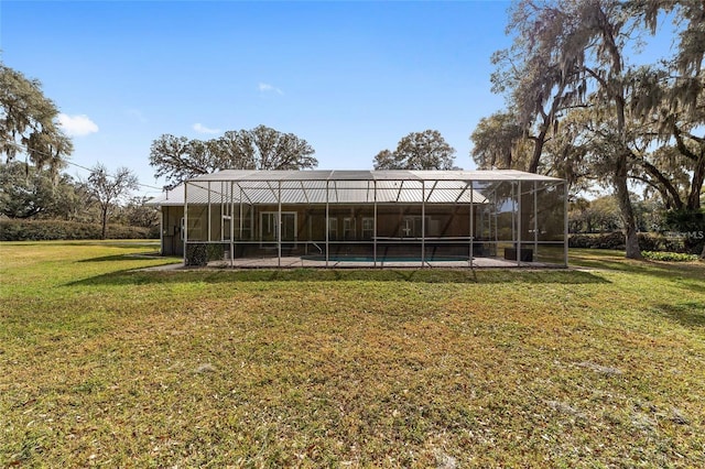 back of property featuring a lanai and a yard