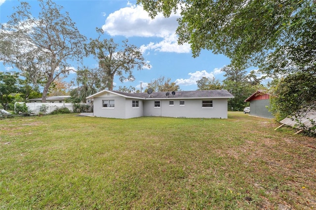 rear view of house featuring a lawn