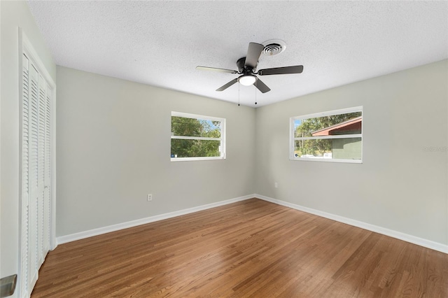 unfurnished bedroom with ceiling fan, a closet, and hardwood / wood-style flooring