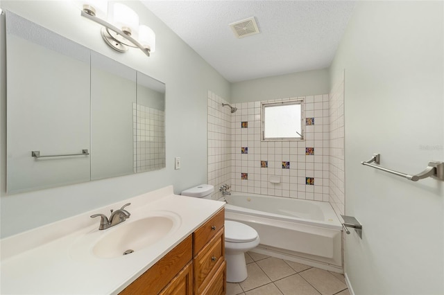 full bathroom with vanity, tile patterned floors, tiled shower / bath, toilet, and a textured ceiling