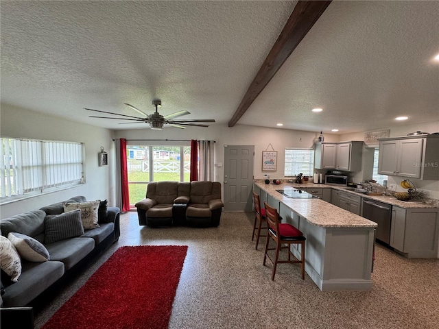 living room with a textured ceiling, ceiling fan, and beam ceiling