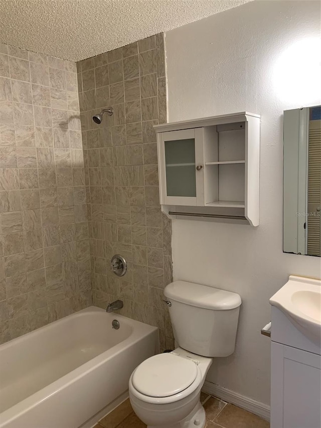 full bathroom featuring vanity, tiled shower / bath, tile patterned flooring, toilet, and a textured ceiling