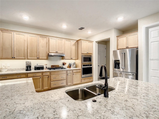 kitchen featuring light brown cabinets, sink, light stone counters, and stainless steel appliances