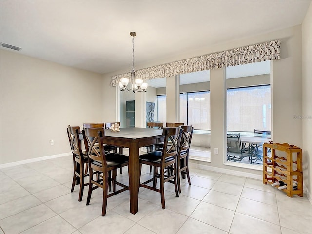 dining space featuring light tile patterned flooring and an inviting chandelier