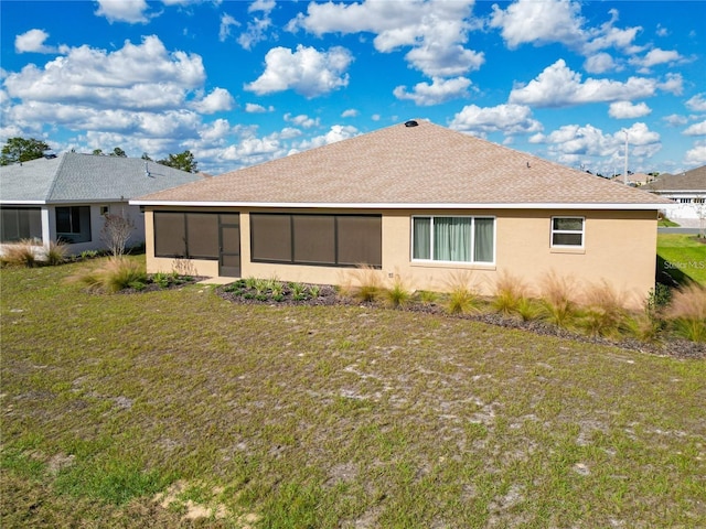 rear view of house with a sunroom and a lawn