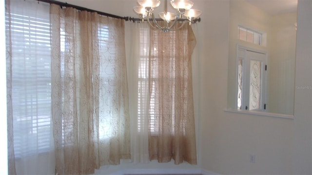 unfurnished room featuring a chandelier