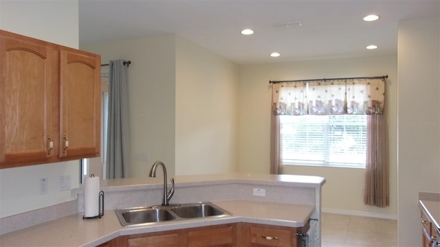 kitchen with kitchen peninsula, sink, and light tile patterned flooring