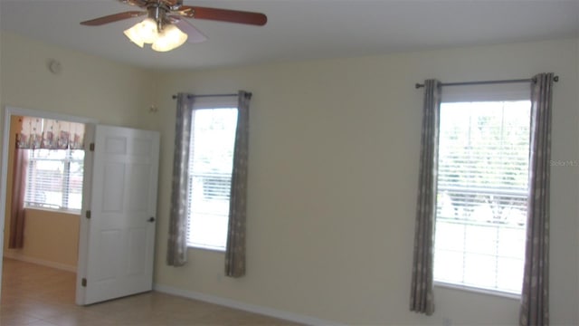 tiled empty room with plenty of natural light and ceiling fan