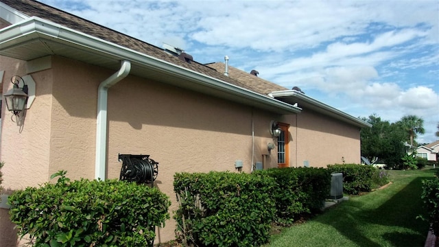 view of property exterior featuring central AC and a yard