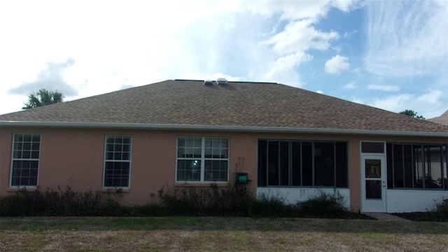 rear view of property featuring a sunroom