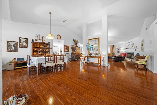 dining room with lofted ceiling, wood-type flooring, and an inviting chandelier