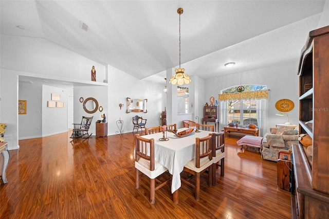 dining space with hardwood / wood-style floors and vaulted ceiling